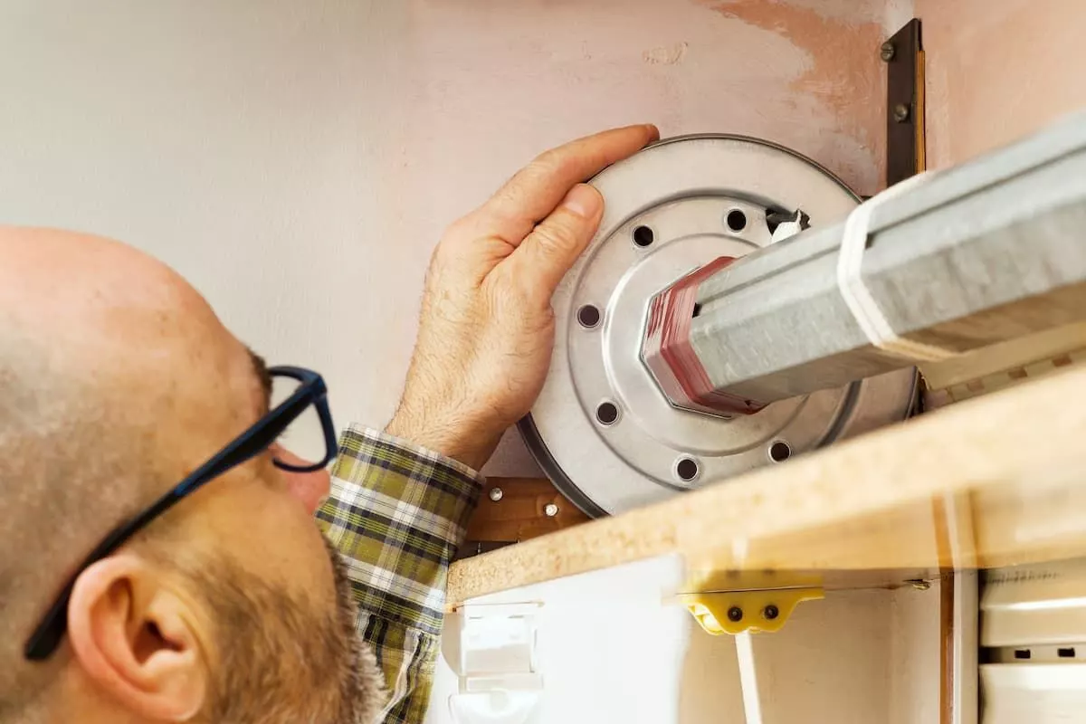 Technicien installant un moteur Nice sur volet manuel à Strasbourg