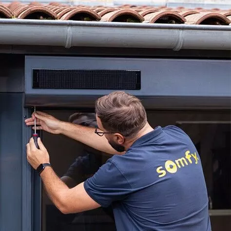 Technicien installant un moteur Somfy lors d'une électrification à Strasbourg